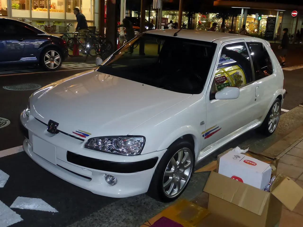 White Peugeot 106 Rallye parked at night.